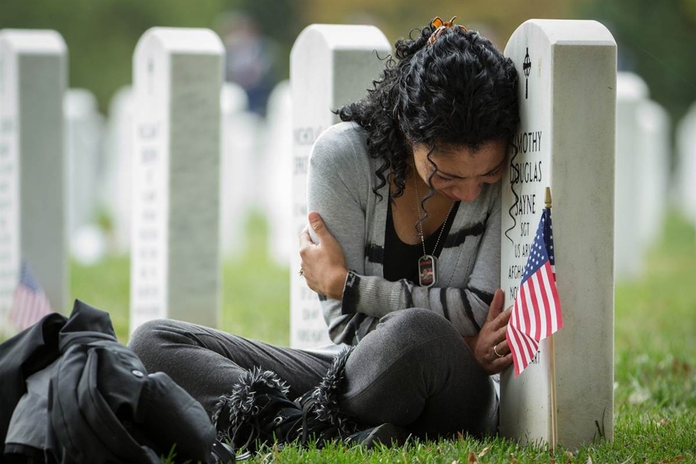 Thania Sayne se penche sur la tombe de son mari, qui a été tué en Afghanistan en 2011, au cimetière national d'Arlington.